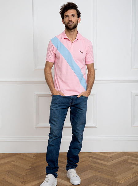 Man wearing pale pink 100% cotton polo shirt with sky blue sash detail and Newmarket 875 horse logo embroidered on the front.